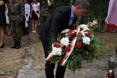 Paweł Nowik składa kwiaty przy pomniku poległych żołnierzy Uderzeniowych Batalionów Kadrowych