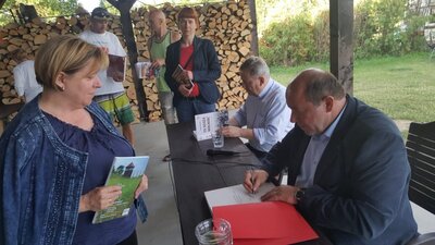 Dyrektor Oddziału IPN w Białymstoku dr hab. Piotr Kardela (na pierwszym planie) oraz Dariusz Jarosiński podpisują wydawnictwa