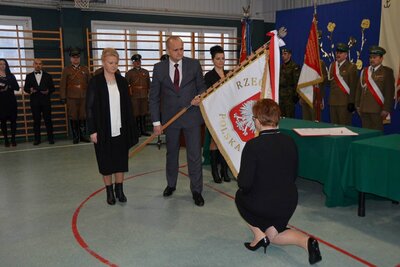 Dyrektor szkoły Alicja Dorohowska przyjmuje nowy sztandar (fot. ze strony internetowej SP w Jeleniewie)
