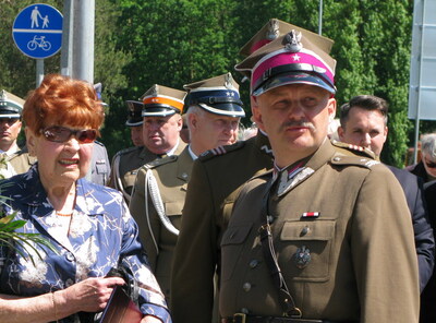 Prezes Eugenia Kula w towarzystwie żołnierzy i rekonstruktorów