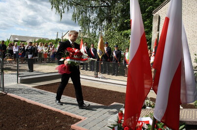 Złożenie kwiatów pod krzyżem upamiętniającym niemiecką zbrodnię