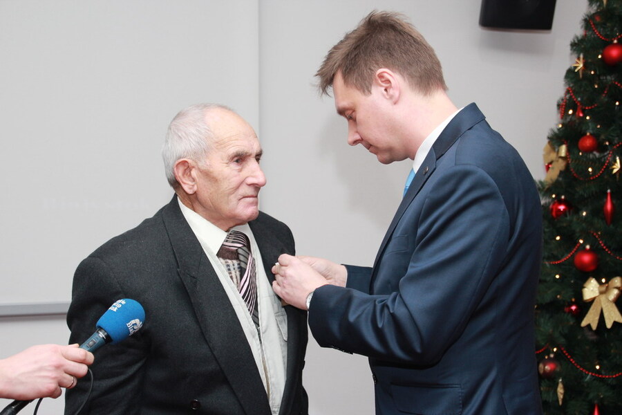 Dr Żuławnik wręcza odznake honorową Kazimierzowi Busmie